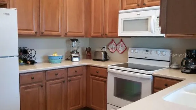 a kitchen with stainless steel appliances granite countertop a refrigerator a stove a sink dishwasher with a dining table and chairs