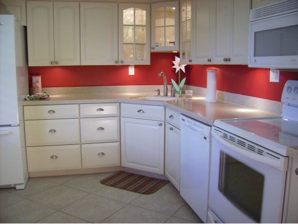 415 Augusta Boulevard, Unit 310 Naples, FL 34113 - Photo 5 of 15 a kitchen with white cabinets and sink