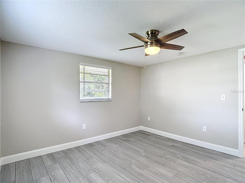 14306 Guava Street Hudson, FL 34667 - Photo 12 of 39 wooden floor in an empty room with a window
