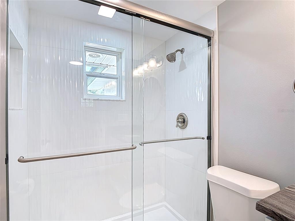 14306 Guava Street Hudson, FL 34667 - Photo 20 of 39 a bathroom with a shower a toilet and sink