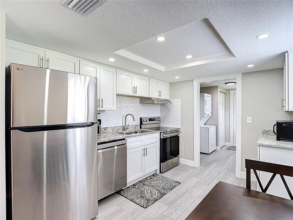 14306 Guava Street Hudson, FL 34667 - Photo 7 of 39 a kitchen with stainless steel appliances a refrigerator sink and cabinets