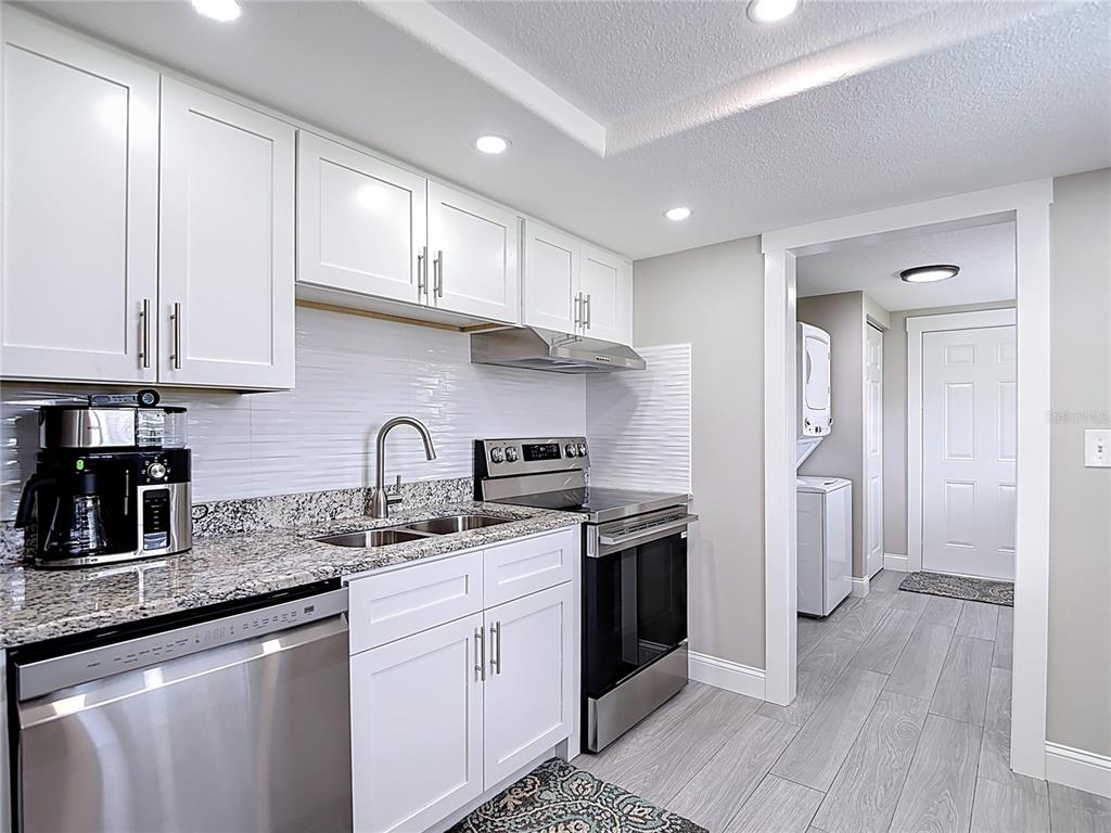 14306 Guava Street Hudson, FL 34667 - Photo 8 of 39 a kitchen with stainless steel appliances granite countertop a sink stove and refrigerator