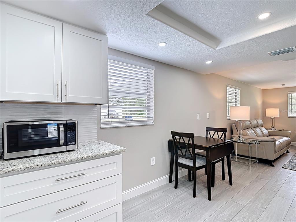 14306 Guava Street Hudson, FL 34667 - Photo 10 of 39 a kitchen with granite countertop white cabinets dining table and chairs
