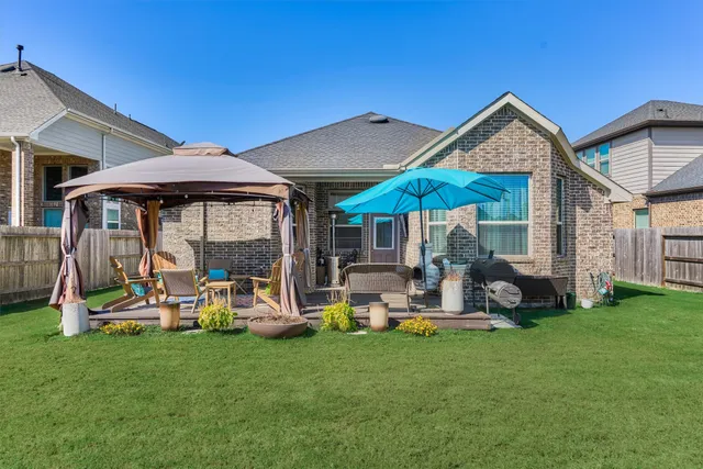 a view of backyard with brick wall and a chair