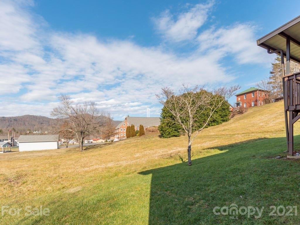 89 Pebblebrook Street Clyde, NC 28721 - Photo 14 of 17 a view of a big yard with an empty house
