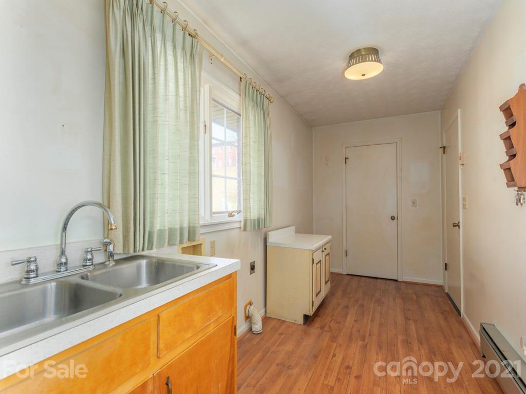 89 Pebblebrook Street Clyde, NC 28721 - Photo 8 of 17 a kitchen with a sink and wooden floors