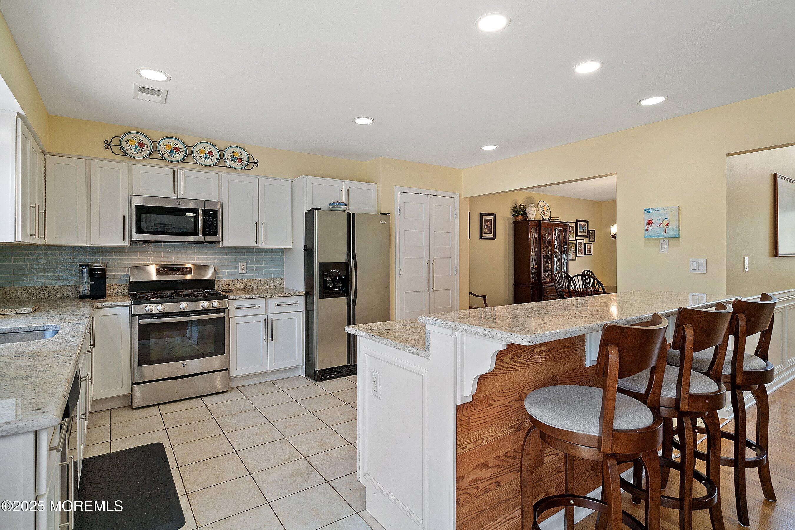 39 Ivy Court Bayville, NJ 08721 - Photo 7 of 33 a kitchen with stainless steel appliances granite countertop a stove a sink a microwave a refrigerator and cabinets