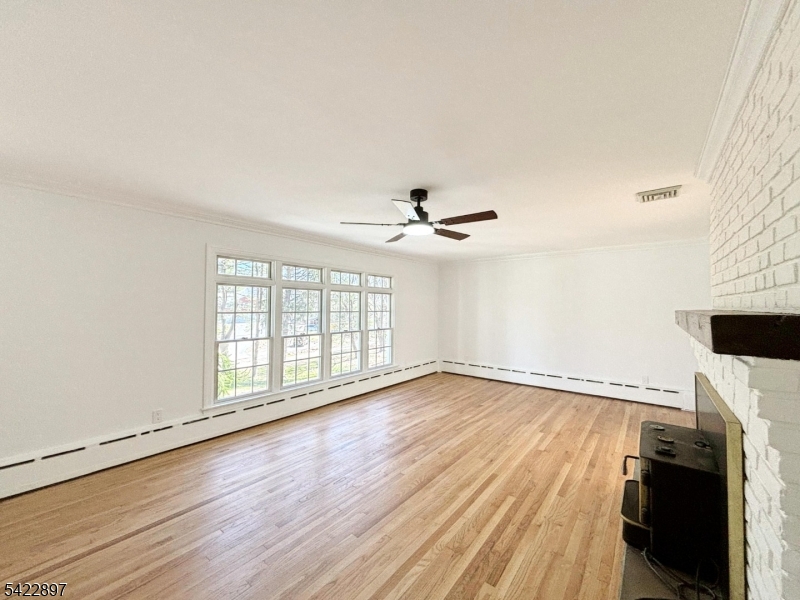 4 Baker Road Vernon, NJ 07461 - Photo 4 of 30 an empty room with wooden floor fan and windows