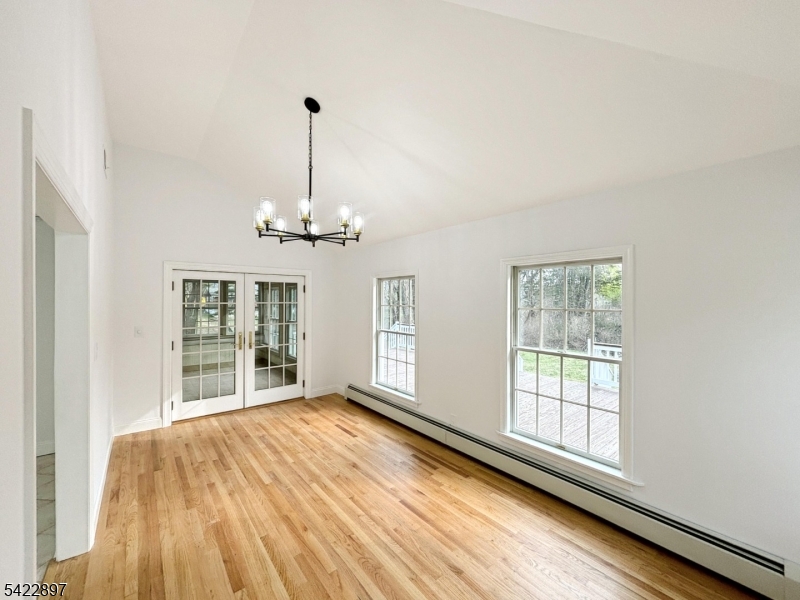 4 Baker Road Vernon, NJ 07461 - Photo 6 of 30 an empty room with wooden floor chandelier and windows