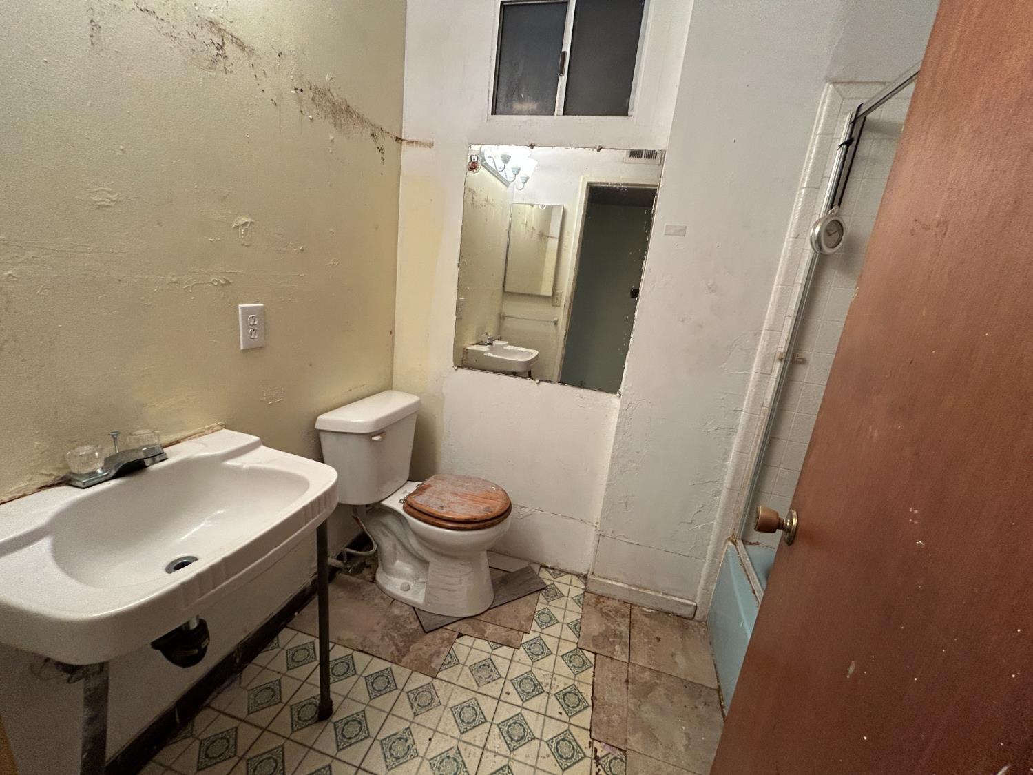 755 H Street Parlier, CA 93648 - Photo 13 of 22 a bathroom with a sink and mirror with toilet