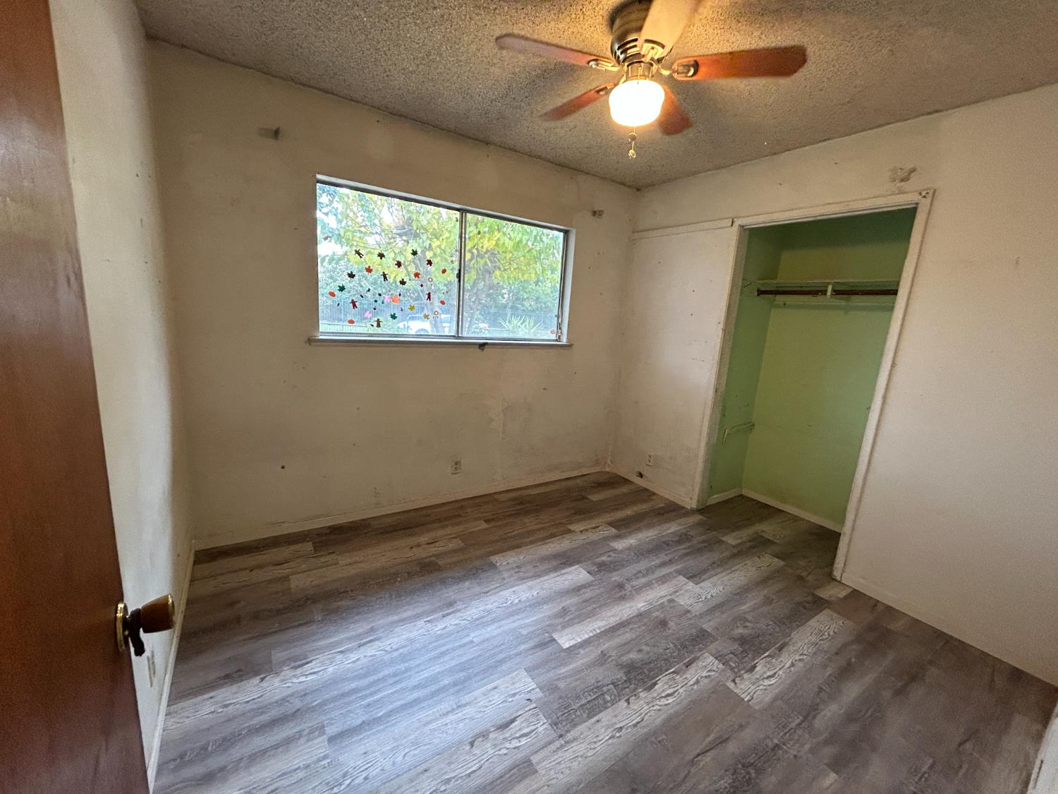 755 H Street Parlier, CA 93648 - Photo 15 of 22 an empty room with wooden floor closet and fan