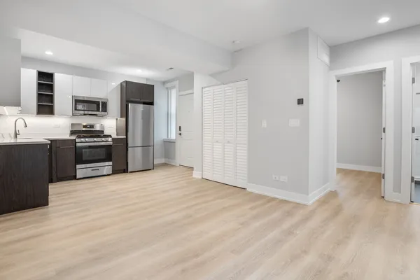 a view of kitchen with stainless steel appliances granite countertop a refrigerator and a sink