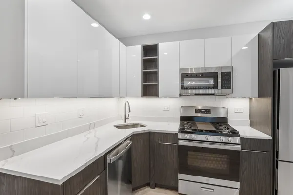 a kitchen with stainless steel appliances a stove microwave and sink