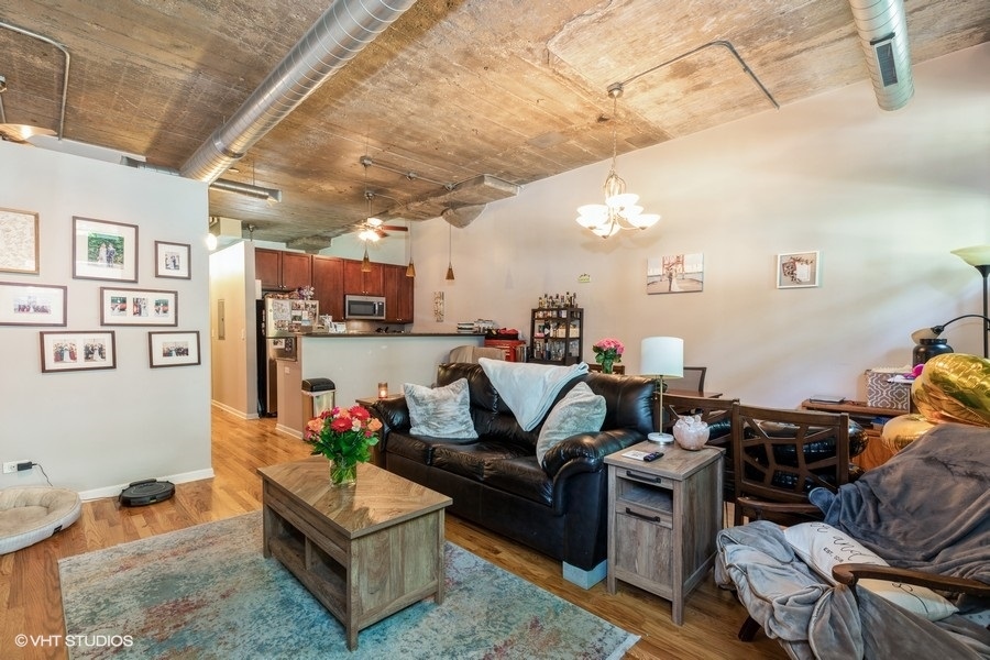 1070 West 15th Street, Unit 102 Chicago, IL 60608 - Photo 12 of 20 a living room with furniture and a chandelier