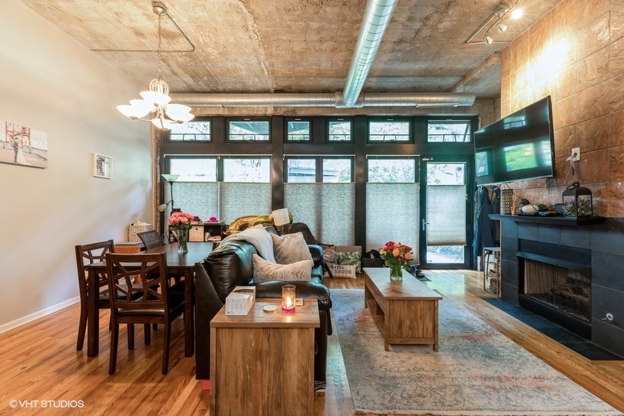 1070 West 15th Street, Unit 102 Chicago, IL 60608 - Photo 6 of 20 a living room with furniture a fireplace and a floor to ceiling window