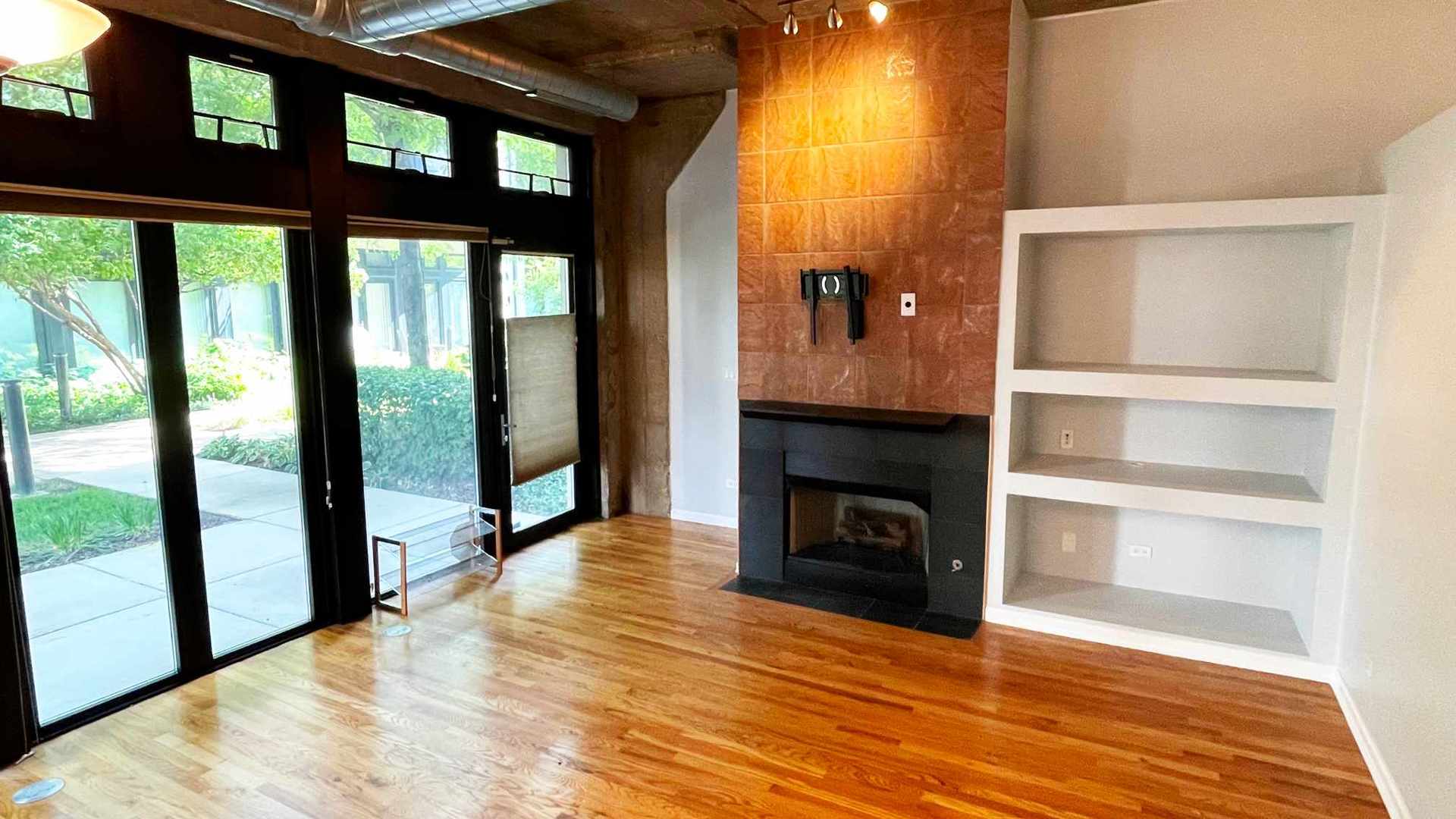 1070 West 15th Street, Unit 102 Chicago, IL 60608 - Photo 9 of 20 a view of an empty room with wooden floor and a window