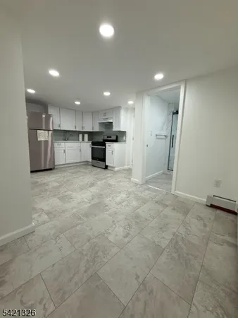 a view of a kitchen with refrigerator and a sink