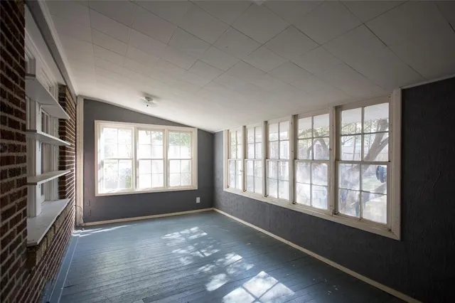 a view of a room with wooden floor and windows
