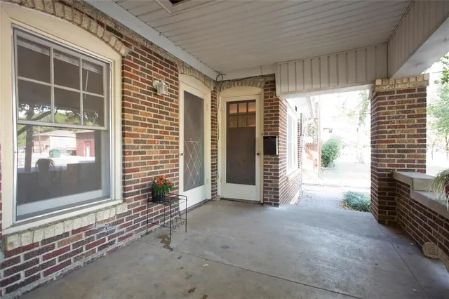 a view of a porch with a floor to ceiling window and wooden floor