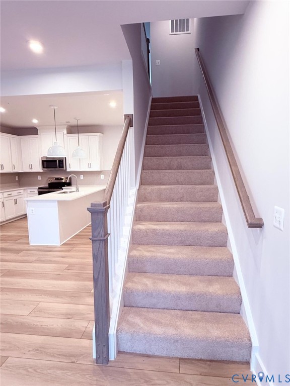 3628 Edna Path, Unit A Henrico, VA 23231 - Photo 5 of 7 Carpeted staircase with wood handrails and white b