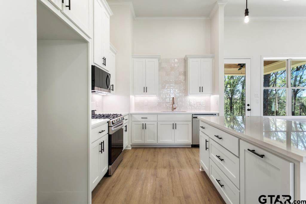 496 Preston Rdg Drive Tyler, TX 75703 - Photo 11 of 34 a kitchen with white cabinets stainless steel appliances a sink and a large window