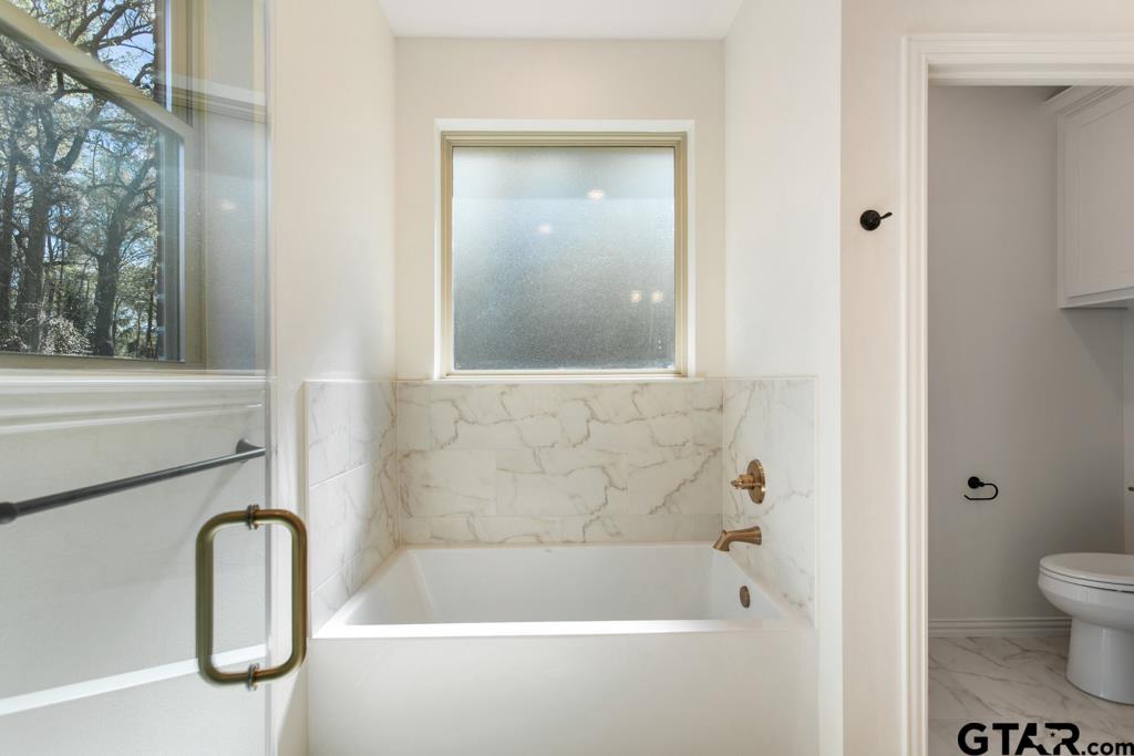 496 Preston Rdg Drive Tyler, TX 75703 - Photo 28 of 34 a bathroom with a tub and a shower