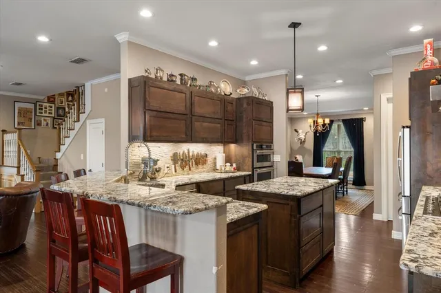 a kitchen with a refrigerator a sink and chairs