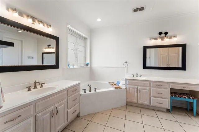 a spacious bathroom with a double vanity sink mirror and bathtub