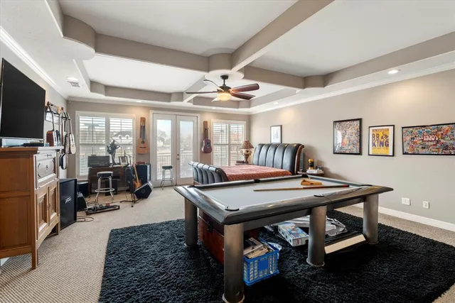 a room with furniture pool table flat screen tv and windows