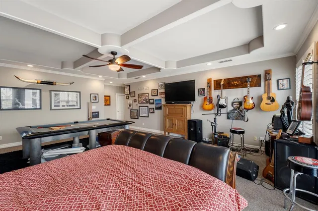 a large bedroom with furniture a flat screen tv and a sink