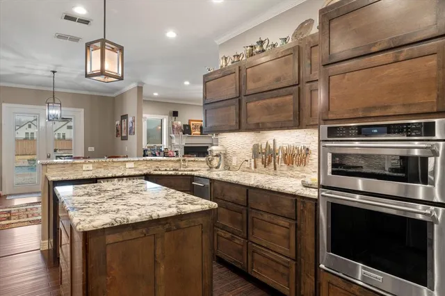 a kitchen with kitchen island granite countertop a stove cabinets and microwave