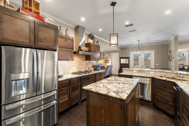 a kitchen with stainless steel appliances granite countertop a sink stove and refrigerator