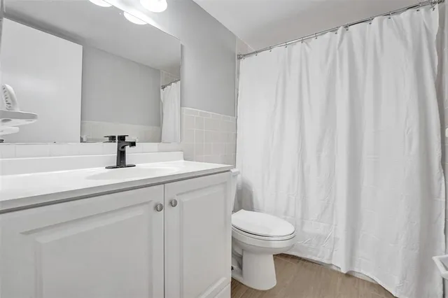 a bathroom with a sink a toilet and a mirror