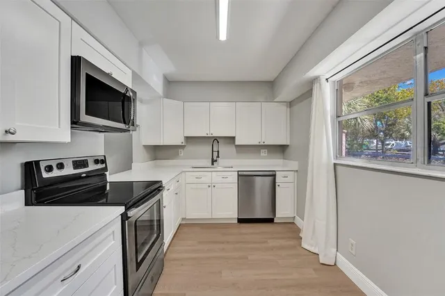 a kitchen with stainless steel appliances a stove sink microwave and cabinets