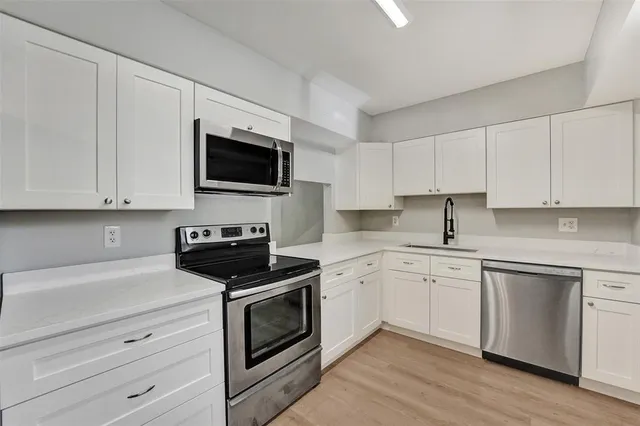 a kitchen with white cabinets and white appliances