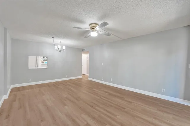 a view of an empty room with a ceiling fan and window