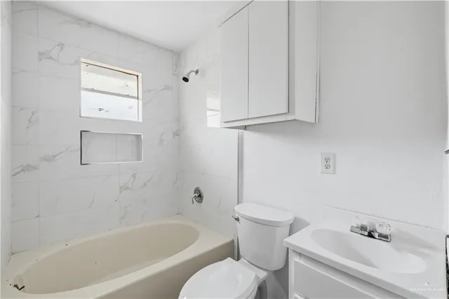 a white bath tub sitting next to a white toilet and sink