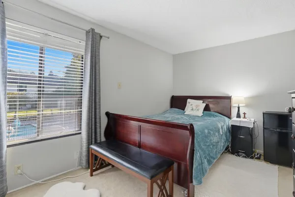 a bedroom with a bed and a flat tv screen on dresser