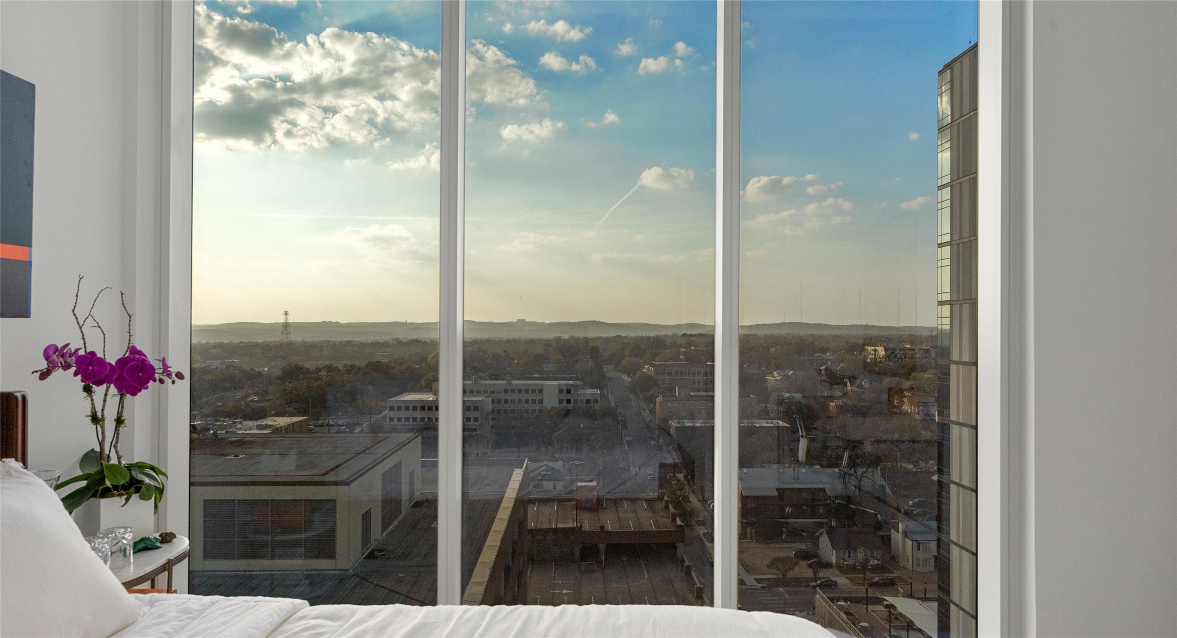 313 West 17th Street, Unit 1104 Austin, TX 78701 - Photo 36 of 40 Bright and versatile second bedroom with floor-to-ceiling windows that capture breathtaking sunsets over the Hill Country. A flexible space that easily transitions into a guest room, home office, or creative retreat.