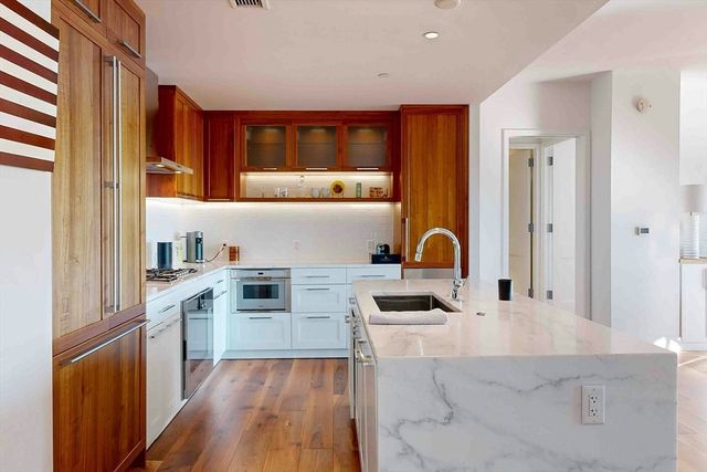 a kitchen with a sink a stove cabinets and wooden floor