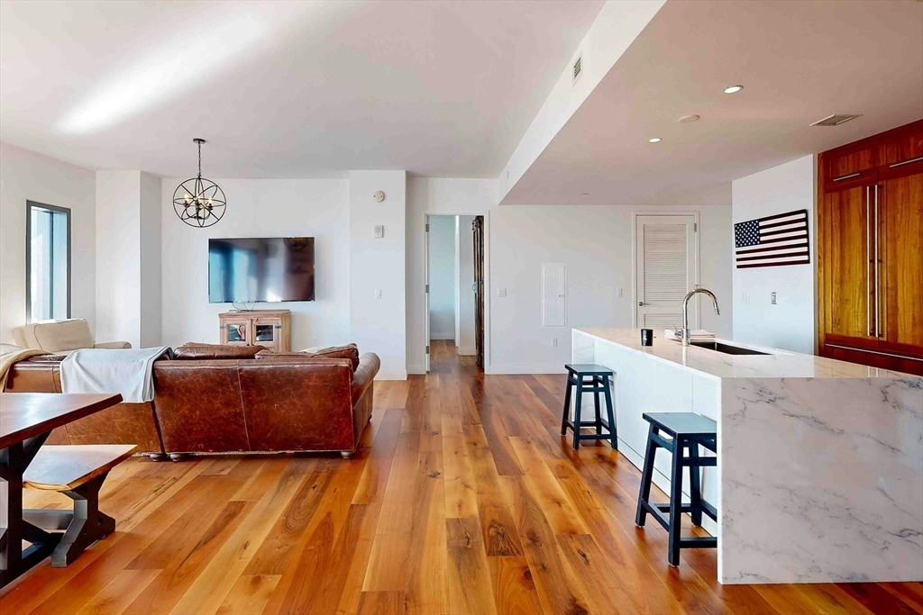 300 Pier 4 Blvd., Unit 6E Boston, MA 02210 - Photo 20 of 36 a living room with furniture and a wooden floor