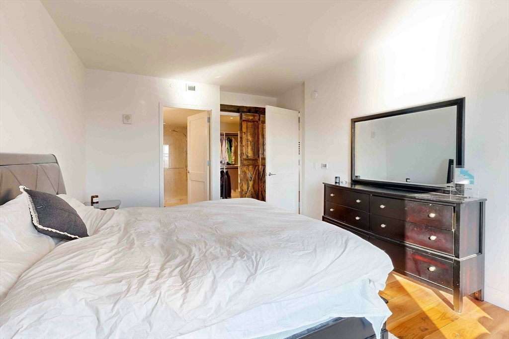 300 Pier 4 Blvd., Unit 6E Boston, MA 02210 - Photo 24 of 36 a bedroom with a bed and a flat screen tv