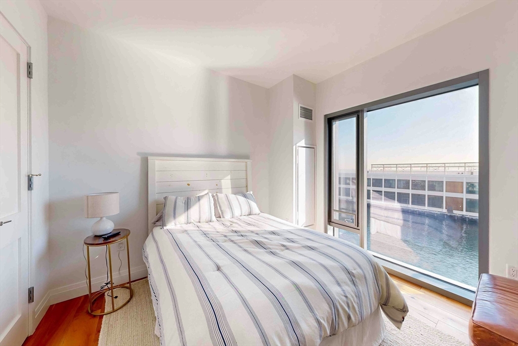 300 Pier 4 Blvd., Unit 6E Boston, MA 02210 - Photo 28 of 36 a bedroom with a bed and a large window