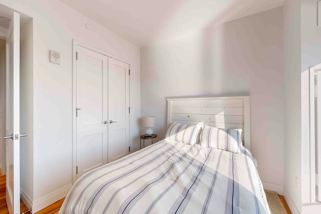 300 Pier 4 Blvd., Unit 6E Boston, MA 02210 - Photo 30 of 36 a bedroom with a bed and a mirror