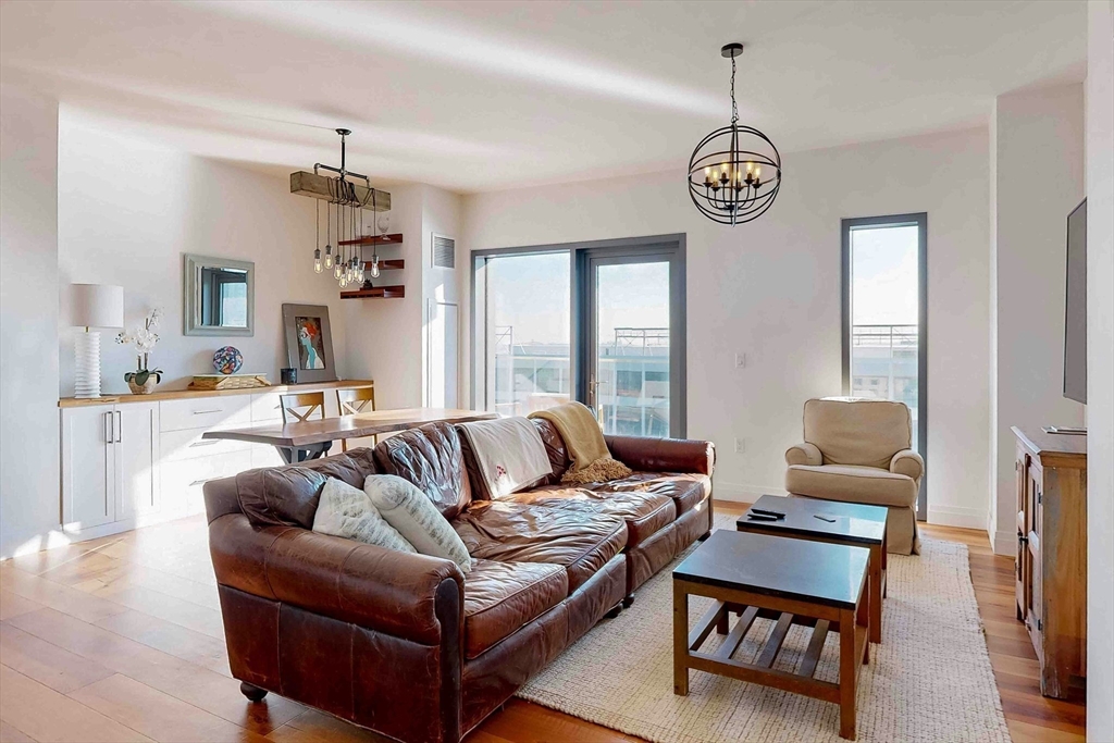 300 Pier 4 Blvd., Unit 6E Boston, MA 02210 - Photo 10 of 36 a living room with furniture a dining table and a window