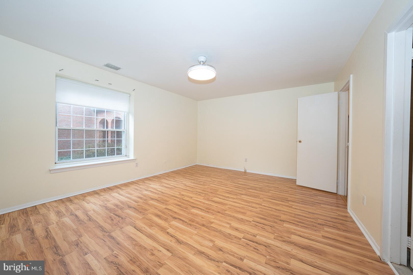 4000 Gypsy Lane, Unit 316A Philadelphia, PA 19129 - Photo 14 of 30 a view of an empty room with wooden floor and a window