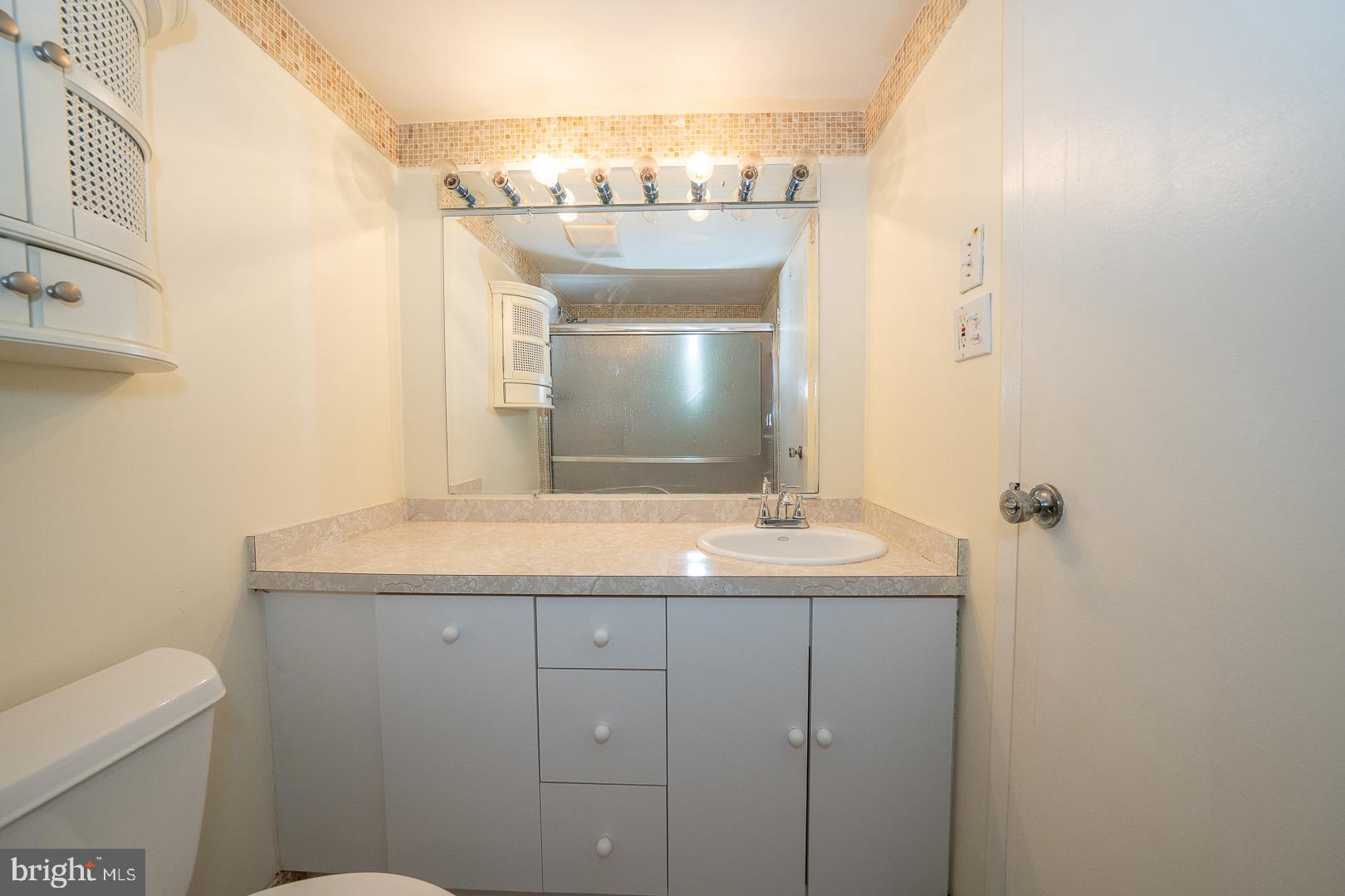 4000 Gypsy Lane, Unit 316A Philadelphia, PA 19129 - Photo 15 of 30 a bathroom with a granite countertop sink a toilet and a mirror