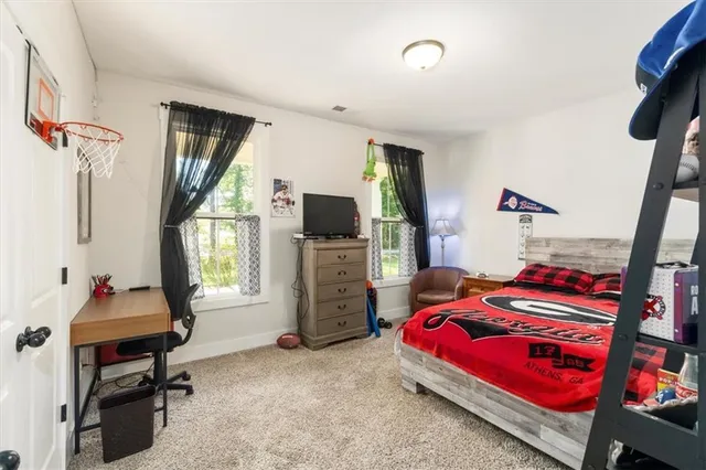 a view of a hallway with wooden floor and a bathroom