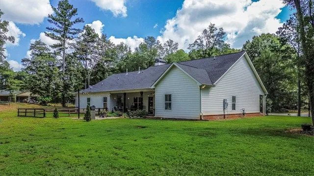 a front view of house with yard and trees in the background