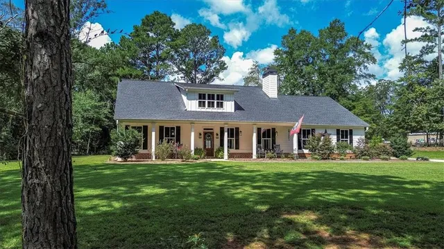 a front view of house with yard and trees around
